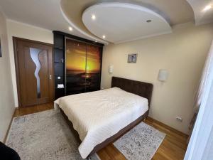 um quarto com uma cama branca num quarto em Bulvar em Ivano-Frankivsʼk