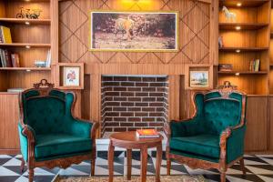 2 Stühle im Wohnzimmer mit Kamin in der Unterkunft WelcomHeritage Santa Roza Kasauli in Kasauli