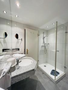 W łazience znajduje się prysznic, umywalka i wanna. w obiekcie Hotel Sonnenberg Garni w mieście Hinterzarten