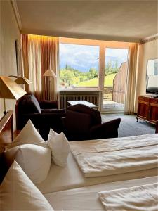 a hotel room with a bed and a large window at Hotel Sonnenberg Garni in Hinterzarten