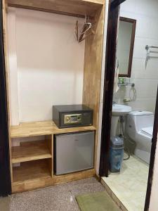 a bathroom with a tv on a shelf in a bathroom at Liberty Place in Luang Prabang
