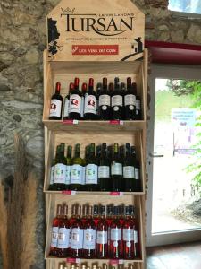 a bunch of bottles of wine on a shelf at Studio privé avec cuisine sdb et terrasse privés in Saint-Sever