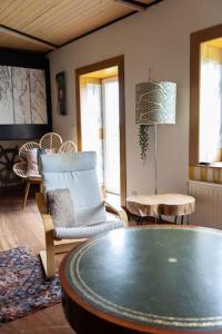 a living room with a table and a chair at Groeps-, Retreat- en Trainingsaccomodatie De Waterkroon! in Wieringerwaard