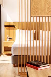 ein Schlafzimmer mit einem Bett mit einem Kinderbett aus Holz in der Unterkunft DAYS City Suites Athens in Athen