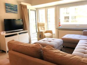 - un salon avec un canapé et une télévision dans l'établissement Vakantieappartement "The Seagull" vlakbij het strand, à Nieuport
