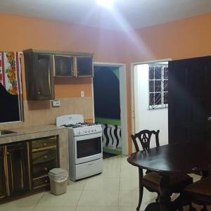 a kitchen with a stove and a table in it at PINE VALLEY ESTATES 9b BALCONY VIEW TWO BEDROOM 2 BATHROOMS 