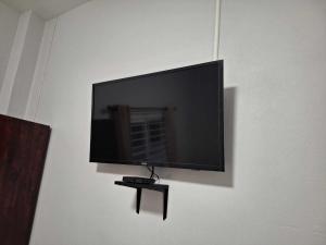 una TV a schermo piatto appesa a un muro di PPN Garden Resort a Suwannaphum