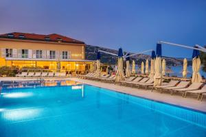 a hotel swimming pool with chairs and umbrellas at Hotel Dobrovit in Baška +37 photos