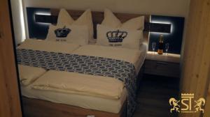 Schlafzimmer mit einem Bett mit weißer Bettwäsche und Kissen in der Unterkunft Chalet Münsterstadl in Altmünster