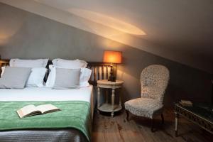 a hotel room with a bed and a chair at Commanderie de Peyrassol in Flassans-sur-Issole