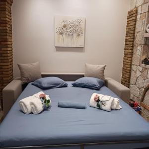 a blue bed with two pillows on top of it at Boutique Eptalofos 15min from airoport and sea in Kouvarás