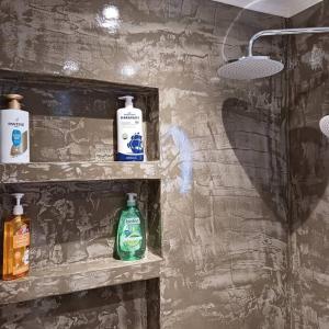 two bottles ofodorizers sit on shelves in a bathroom at Boutique Eptalofos 15min from airoport and sea in Kouvarás