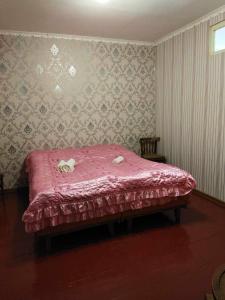 Guesthouse Irina Family Hotel في Tsvirmi: غرفة نوم مع سرير وردي مع اثنين من الكلاب يستلقون عليها