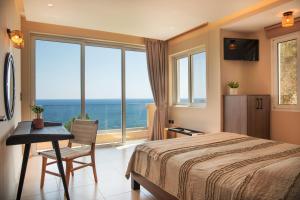 a bedroom with a bed and a view of the ocean at Creta Spirit in Plakias