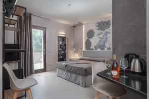 Schlafzimmer mit einem Bett, einem Tisch und Stühlen in der Unterkunft Villa Ilma Luxury Rooms in Arzachena