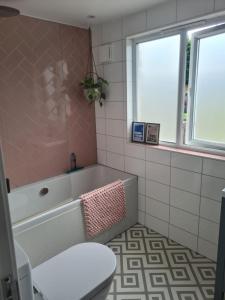 a bathroom with a bath tub and a toilet at South Downs View in Brighton & Hove