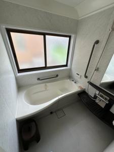 a bathroom with a white sink and a window at Fuji Cottage in Fujikawaguchiko +37 photos