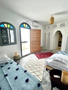 a bedroom with two beds and a large window at Dar Narjis in Asilah