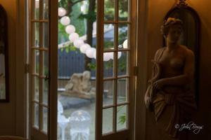 une statue d'une femme debout à côté d'une fenêtre dans l'établissement Maxwell Mansion Hotel, à Lake Geneva