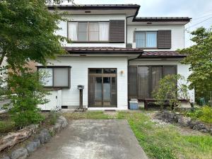a white house with a bench in front of it at Fuji Cottage in Fujikawaguchiko