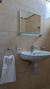 a bathroom with a sink and a mirror and a towel at Stoyanovi Guest House in Chernomorets