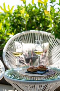 zwei Gläser Wein auf einem Tisch mit Essen in der Unterkunft Villa Ilma Luxury Rooms in Arzachena