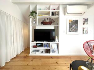 a living room with a tv on a white shelf at Art Cottage with oPorto View! in Vila Nova de Gaia