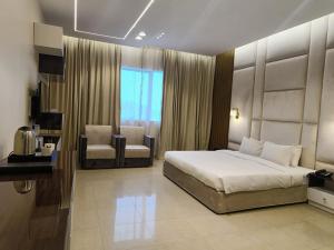 1 dormitorio con 1 cama y 1 silla en Clifton International Hotel, en Fujairah