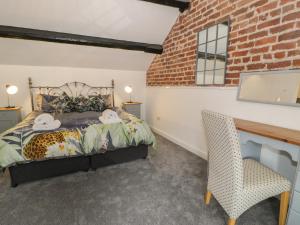 a bedroom with a bed and a brick wall at Conors Cottage in Denbigh