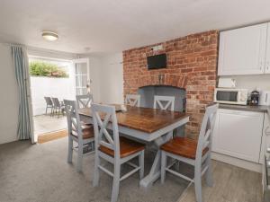 a kitchen and dining room with a brick wall at Walled Garden Cottage in Denbigh