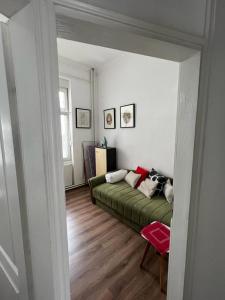ein Schlafzimmer mit einem grünen Bett in einem Zimmer in der Unterkunft Kod bake u centru in Novi Sad