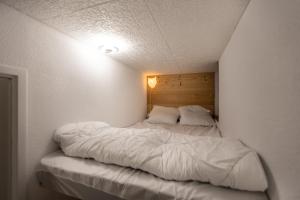 a large white bed in a white room at Les Anglines - Appt proche station de ski in Les Angles