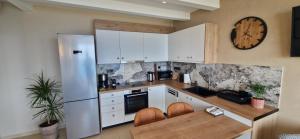 a kitchen with white cabinets and a clock on the wall at Creta Spirit in Plakias