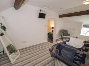 a bedroom with a bed and a mirror and a chair at Walled Garden Cottage in Denbigh