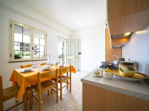 a kitchen with a table and a kitchen with a stove at Residence Olimpo in Capo Vaticano