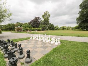 a chess board on a sidewalk in a park at Upper Gardener's Cottage in Denbigh