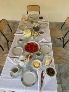 a table with plates and bowls of food on it at Guesthouse Tropojë e Vjeter in Tropojë