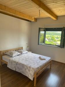 1 dormitorio con 1 cama en una habitación con ventana en Guesthouse Tropojë e Vjeter, en Tropojë