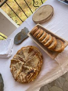 a table with a pie and bread on a table at Guesthouse Tropojë e Vjeter in Tropojë
