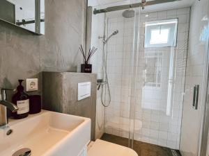 a bathroom with a shower and a sink at Naar de kust in Hollum