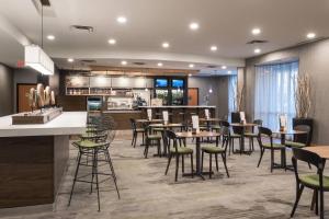 a restaurant with tables and chairs and a bar at Courtyard by Marriott Toronto Vaughan in Vaughan