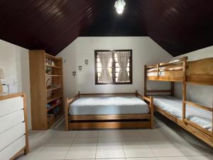 1 Schlafzimmer mit 2 Etagenbetten und einem Fenster in der Unterkunft Chalé no Condomínio Serra Nevada I in Bananeiras