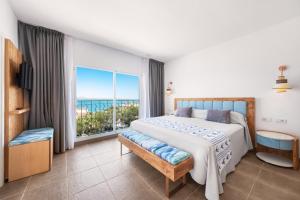 a bedroom with a large bed and a large window at Hotel Villa Chiquita - Adults Only - Over 12 in Colònia de Sant Jordi