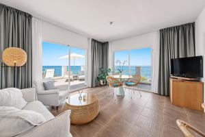 een woonkamer met een bank en een tv bij Hotel Villa Chiquita - Adults Only - Over 12 in Colonia Sant Jordi