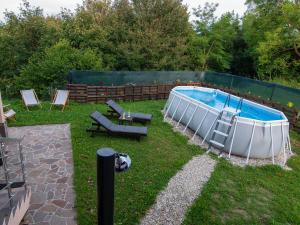 Bizeljsko的住宿－Holiday house Zarja - with sauna and hot tub，庭院内的游泳池,带椅子