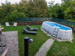 una piscina en un patio con sillas en Holiday house Zarja - with sauna and hot tub en Bizeljsko