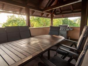 una mesa de madera y sillas en un porche cubierto en Holiday house Zarja - with sauna and hot tub, en Bizeljsko