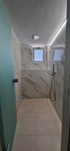 a bathroom with a walk in shower and a window at Creta Spirit in Plakias