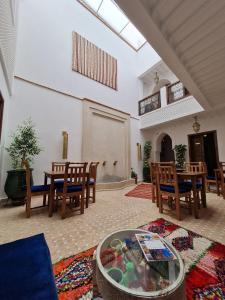 Riad Beni Sidel في مراكش: غرفة معيشة مع طاولة وكراسي في غرفة