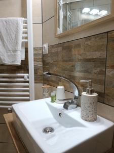 een badkamer met een witte wastafel en een spiegel bij L'Imprévu in Bourisp